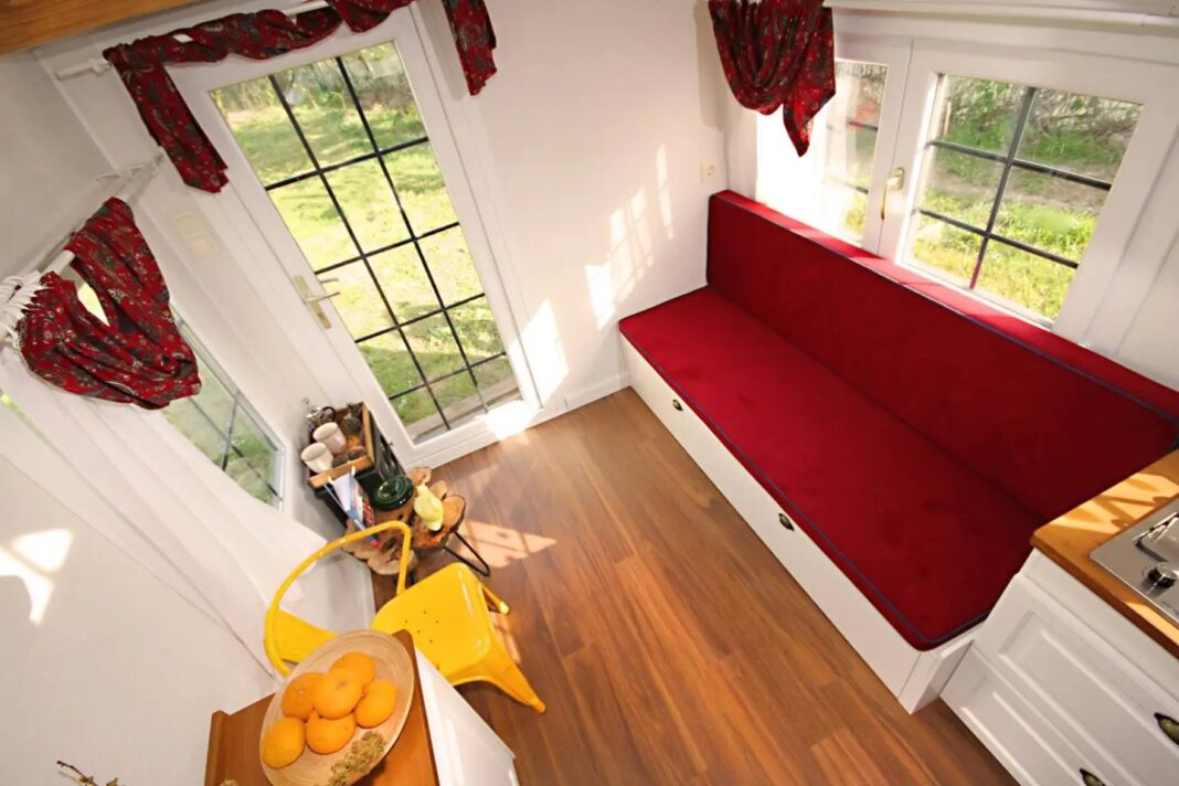 The Sunrise Tiny House's living room includes a sofa bed that sleeps two and has integrated storage
